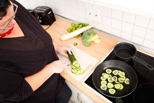 Mulher cortando e fritando pepino — Fotografia de Stock