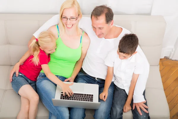 Familie cu laptop pe canapea — Fotografie, imagine de stoc