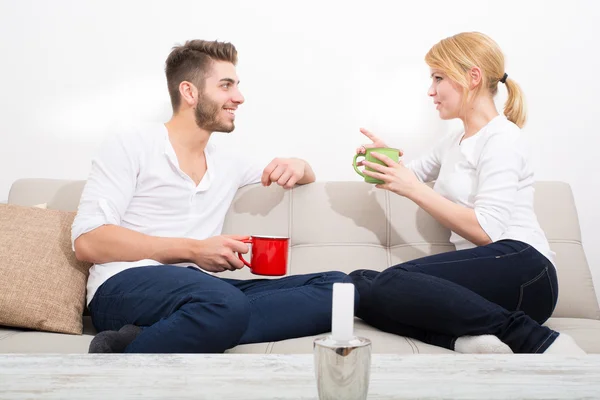 Pareja joven coqueteando en el sofá —  Fotos de Stock