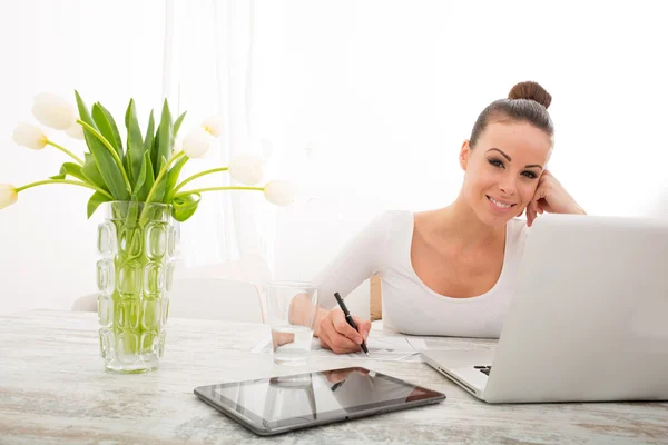 Jeune femme travaillant avec un ordinateur portable Photo De Stock