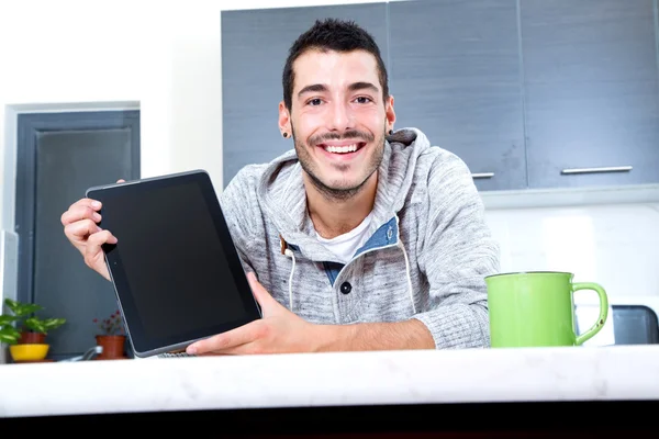 Jovem com tablet na cozinha — Fotografia de Stock