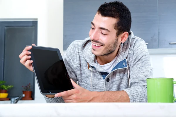 Jonge man met tablet in de keuken — Stockfoto