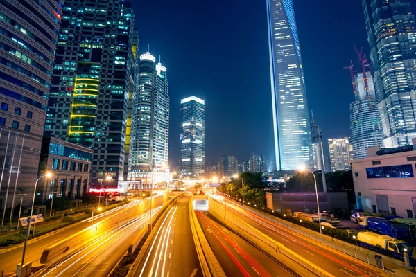 Sentieri luminosi sulla strada con edificio moderno — Foto Stock