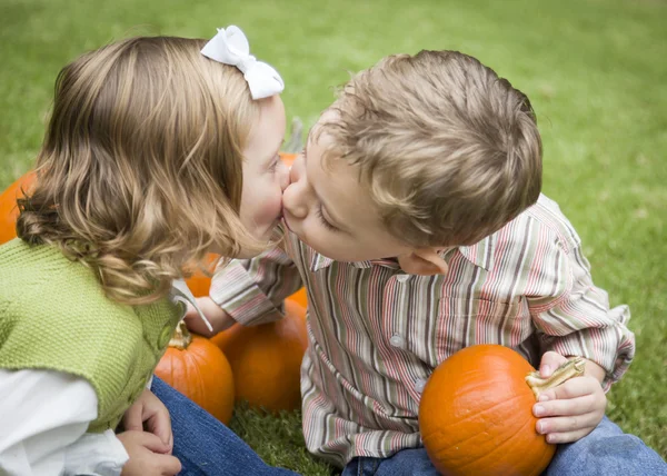 かわいい若い兄と妹、パンプキン パッチでキスします。 — ストック写真