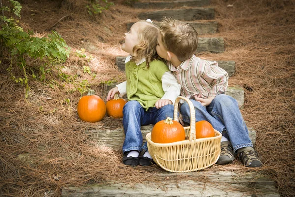 Broer en zus kinderen op houten stappen met pumpkins spelen — Stockfoto