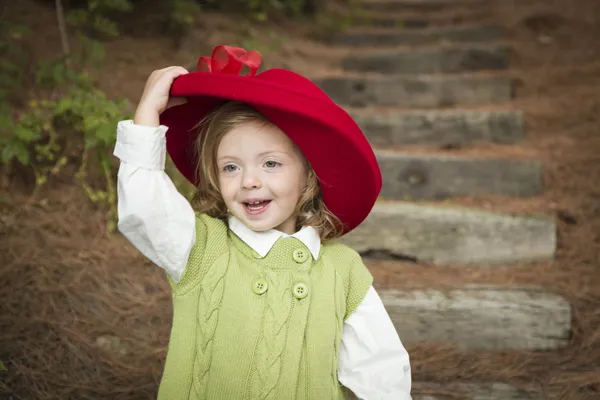 Adorable niña con sombrero rojo jugando fuera —  Fotos de Stock