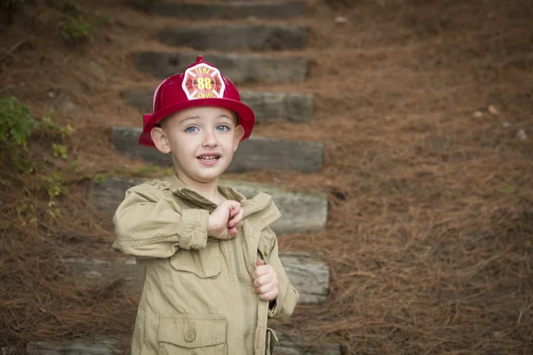 Adorabile bambino ragazzo con cappello da pompiere che gioca fuori — Foto Stock