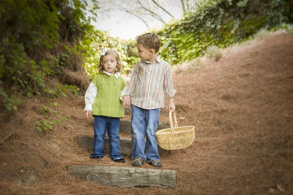 Zwei Kinder gehen mit Korb draußen die Holztreppe hinunter. — Stockfoto