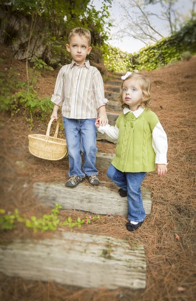 Dwoje dzieci idąc drewna kroki z koszyka poza. — Zdjęcie stockowe