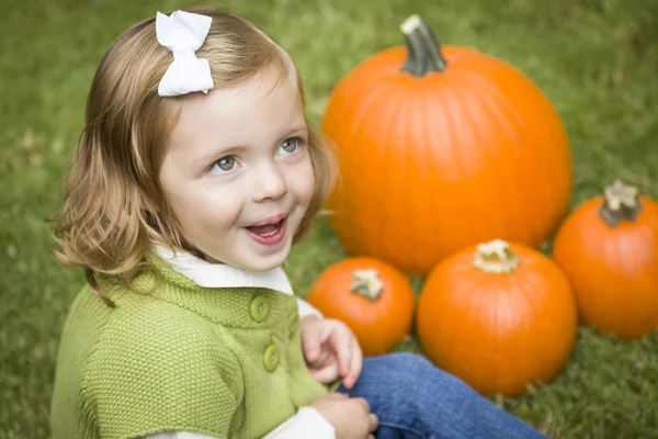 Schattig jong kind meisje genieten van de pompoen patch. — Stockfoto