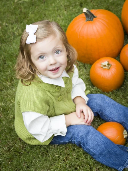 Schattig jong kind meisje genieten van de pompoen patch. — Stockfoto