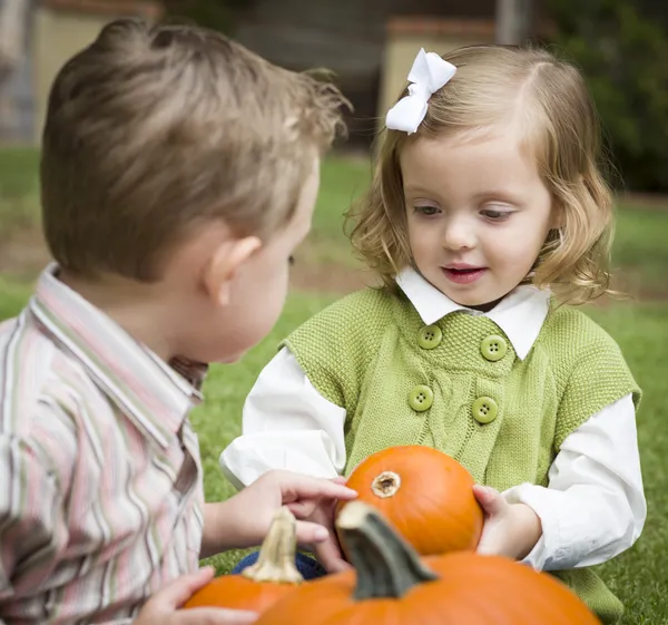 Süße kleine Geschwister am Kürbispflaster — Stockfoto