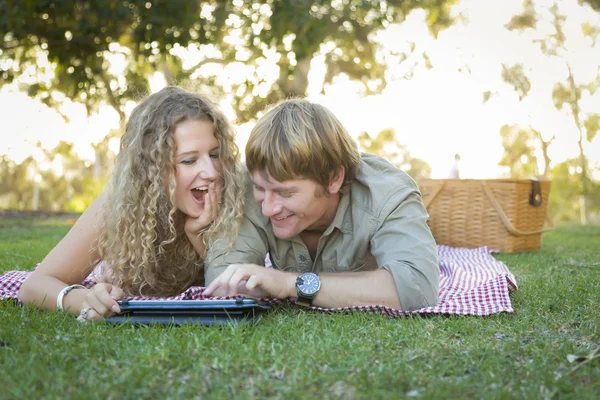 Aantrekkelijke verliefde paar met behulp van een aanrakingsstootkussen buiten — Stockfoto