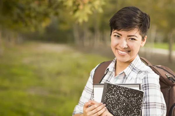 Porträtt av en ganska blandad ras kvinnlig student håller böcker — Stockfoto