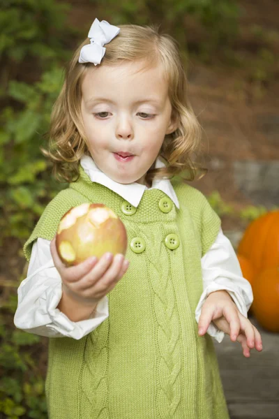 Entzückendes Mädchen isst draußen roten Apfel — Stockfoto