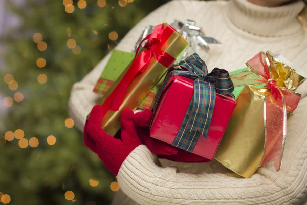 Mulher vestindo luvas vermelhas sazonais segurando presentes de Natal — Fotografia de Stock