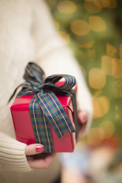 Mujer con manoplas rojas estacionales sosteniendo regalo de Navidad —  Fotos de Stock
