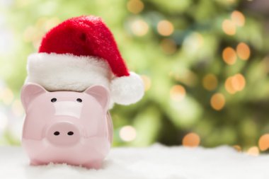 kar taneleri üzerinde santa şapka ile pembe kumbara