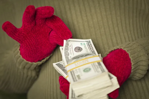 Woman Wearing Mittens Holding Stacks of Money with Red Ribbon