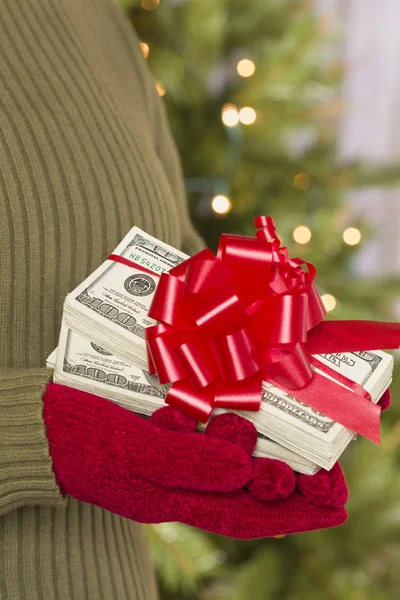 Женщина в рукавицах, держащая пачки денег с красной лентой — стоковое фото