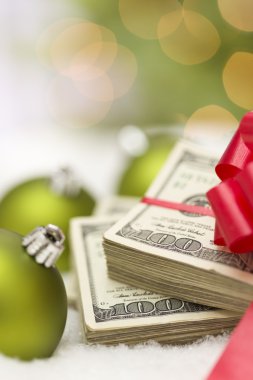 Noel süsler yakınındaki yay ile yüz dolar faturaları yığını