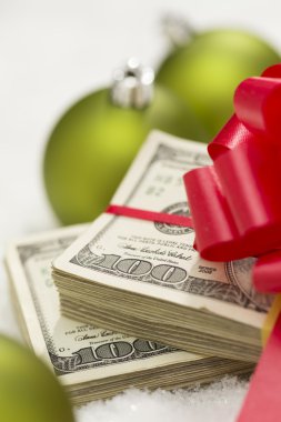 Noel süsler yakınındaki yay ile yüz dolar faturaları yığını