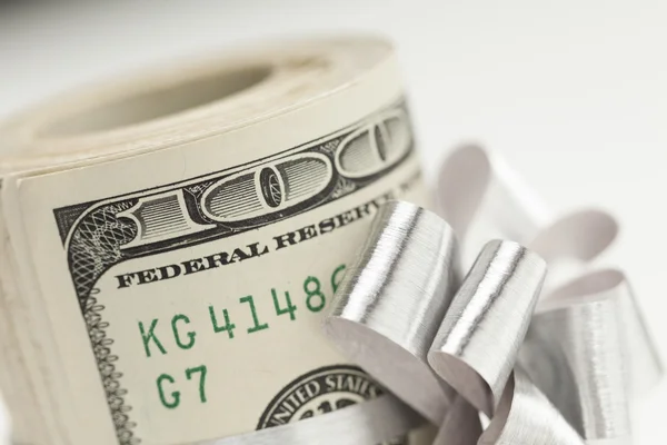 Rolo de cem dólares Bills amarrado arco de prata no branco — Fotografia de Stock