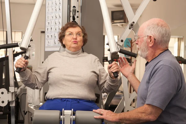 Pareja de adultos mayores haciendo ejercicio juntos en el gimnasio —  Fotos de Stock