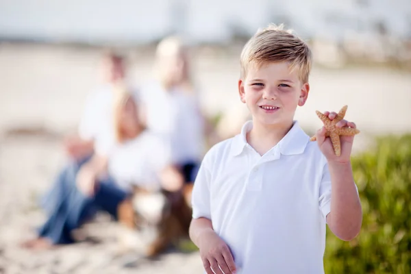 Süße kleine blonde Junge zeigt seine Seesterne — Stockfoto