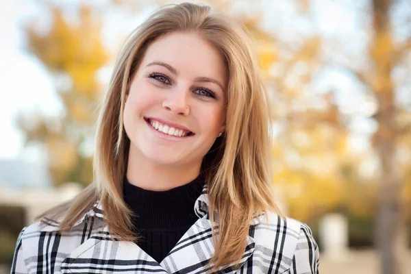 Hübsche junge Frau lächelt im Park — Stockfoto