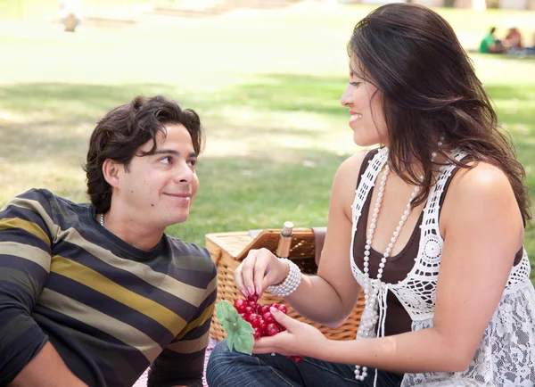 Atractiva pareja hispana haciendo un picnic en el parque — Foto de Stock