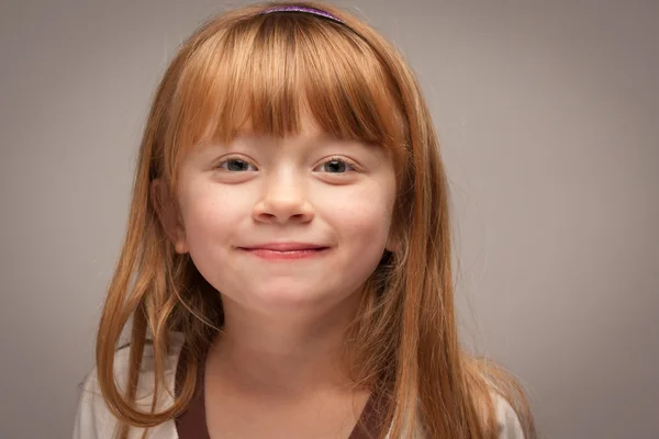 Roliga porträtt av en bedårande röda haired girl på grå — Stockfoto