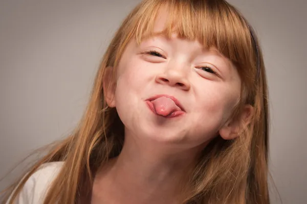 Retrato divertido de uma adorável menina de cabelos vermelhos em cinza — Fotografia de Stock