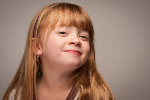 Roliga porträtt av en bedårande röda haired girl på grå — Stockfoto