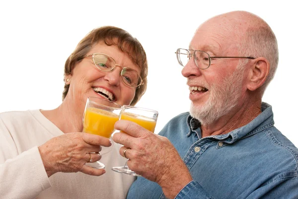 Feliz pareja de ancianos con vasos de jugo de naranja —  Fotos de Stock