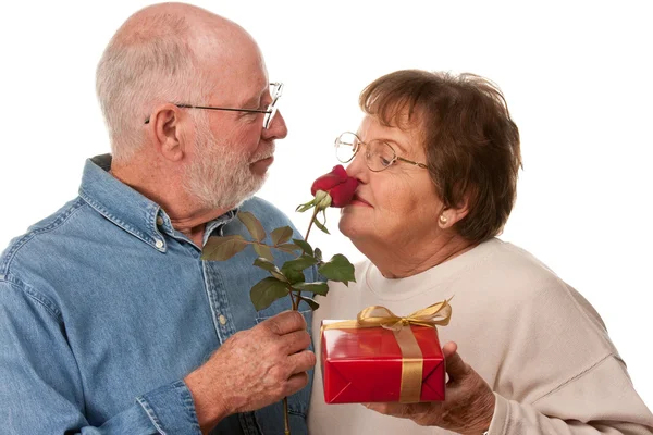 Boldog idősebb pár ajándék és a vörös rózsa — Stock Fotó