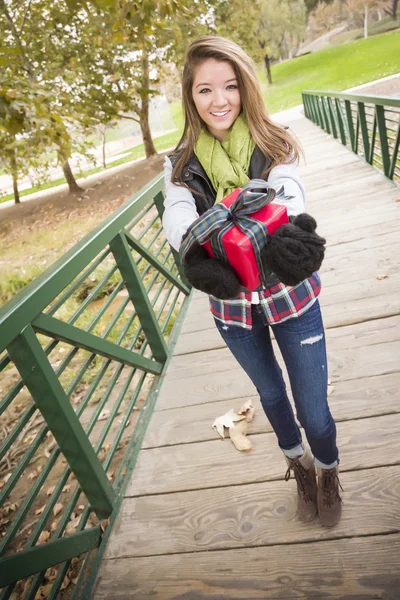 Hübsche Frau mit eingewickeltem Geschenk mit Schleife draußen — Stockfoto