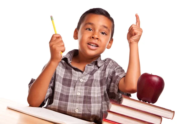Un garçon hispanique lève la main, livre, pomme, crayon et papier — Photo