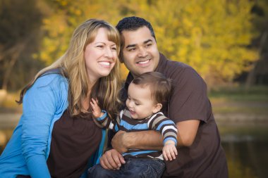 Happy Mixed Race Ethnic Family Playing In The Park