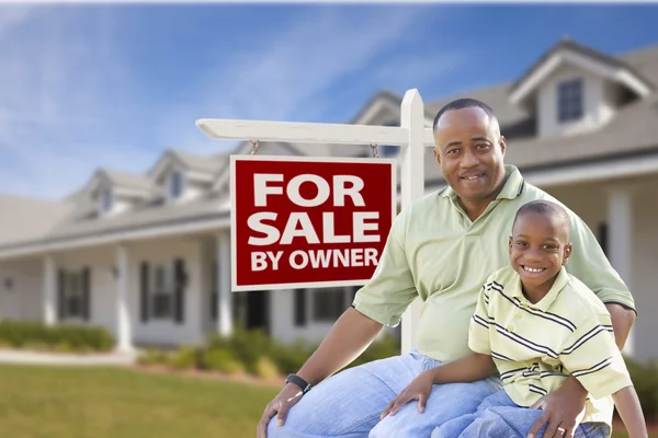 Père et fils devant pour la vente par signe de propriétaire et maison — Photo