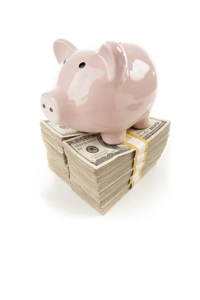 Розовая свинья на стеллажах денег на белом — стоковое фото