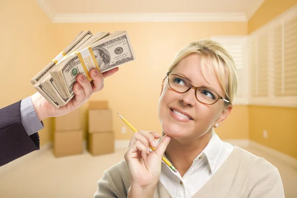 Woman Being Handed Stacks of Money in Empty Room — Stock Photo, Image