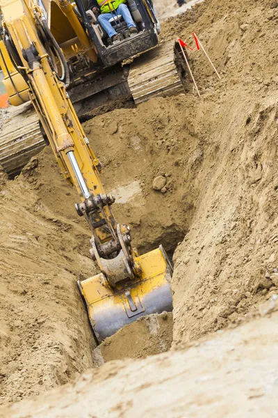 Graafmachine trekker graven van een greppel — Stockfoto