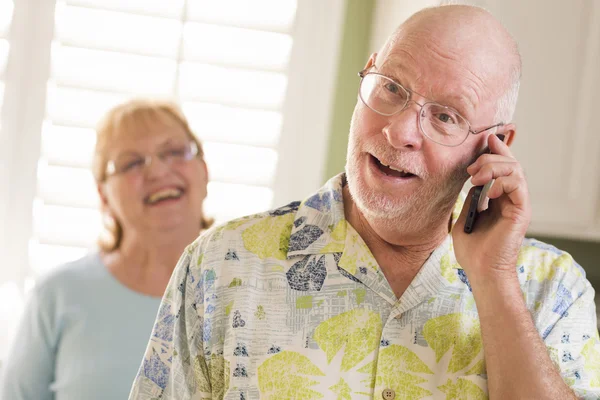 Старший взрослый муж на телефоне с женой за спиной — стоковое фото