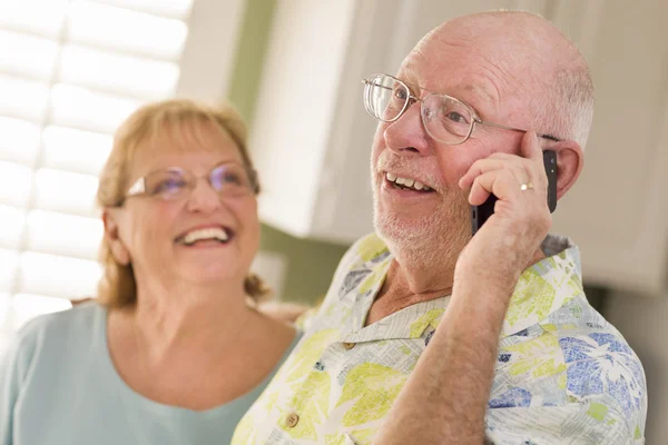 Marito adulto anziano sul cellulare con moglie dietro — Foto Stock