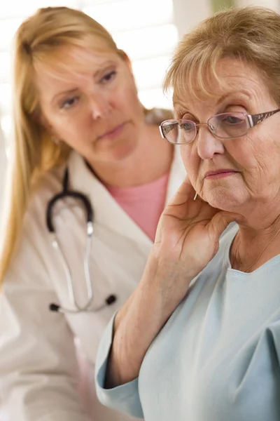 Senior adulto donna essere consolato da femmina medico o infermiera — Foto Stock