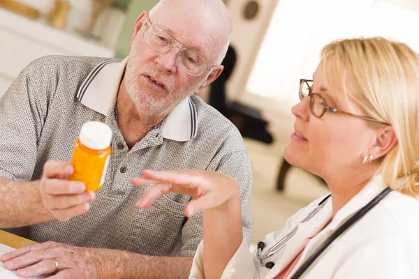 Läkare eller sjuksköterska förklarar receptbelagt läkemedel till äldre man — Stockfoto