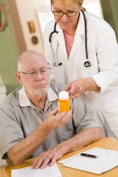 Médico o enfermera explicando la medicina recetada al hombre mayor — Foto de Stock