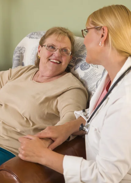 Doutor ou enfermeira conversando com a mulher senta-se sênior — Fotografia de Stock