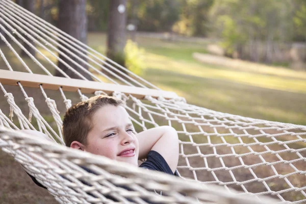 Ung pojke njuter av en dag i sin hängmatta — Stockfoto